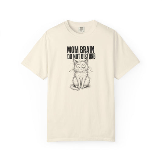 An off-white short-sleeve t-shirt with a black graphic of a cat and the text 'MOM BRAIN DO NOT DISTURB' printed on the front, displayed against a solid white background.
