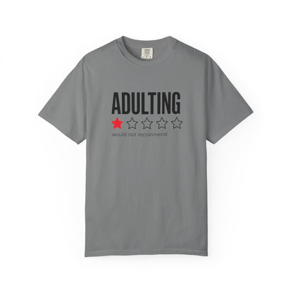 A gray short-sleeve crewneck t-shirt with a graphic on the chest that reads 'ADULTING' in black block letters above a one-out-of-three star rating where only the first star is filled in red, and the text 'would not recommend' in small gray font underneath.