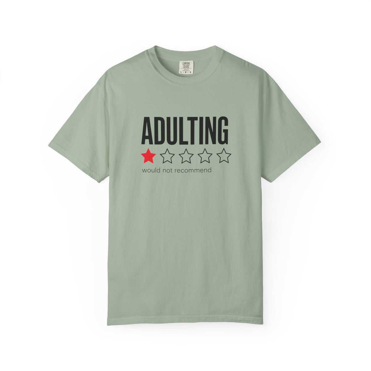 A sage green short-sleeve t-shirt with a graphic on the chest that reads 'ADULTING' in black block letters above a one-star red and three-star black outline graphic, with 'would not recommend' printed below.