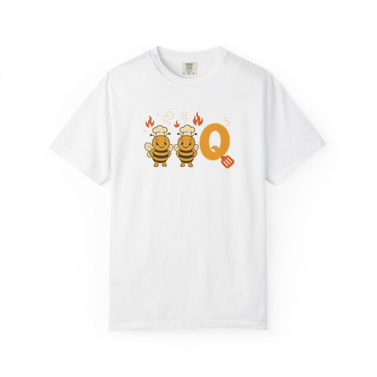 A white short-sleeve crewneck t-shirt featuring a cartoon graphic of two smiling bees wearing chef hats next to a large orange letter 'Q' with small orange flames and a spatula.