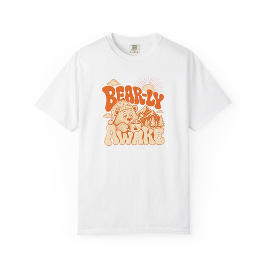 A white short-sleeve crewneck t-shirt featuring a retro-style orange graphic on the chest with the text 'BEARLY AWAKE' and an illustration of a bear, sun, and mountains.