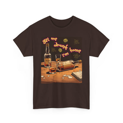 A brown short-sleeve crewneck t-shirt featuring a colorful graphic print on the front. The graphic shows an illustration of whiskey bottles, glasses, and shattered glass on a wooden table, with the text 'get me drunk i'm home' in a wavy orange font.