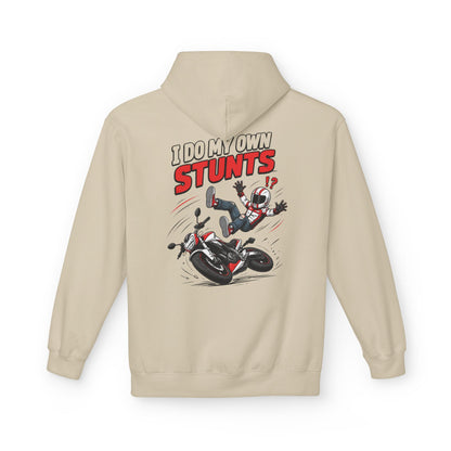 A beige hoodie shown from the back, featuring a graphic print of a cartoon character falling off a motorcycle with the text 'I DO MY OWN STUNTS' in red and black.