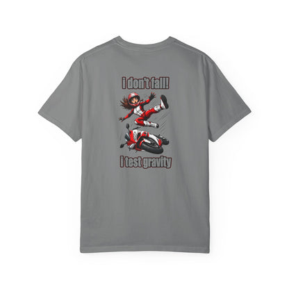 A gray short-sleeve t-shirt with a graphic print on the back showing a cartoon of a girl in a red and white racing suit falling off a red and white motorcycle, with the text 'I don't fall!' above and 'I test gravity' below.