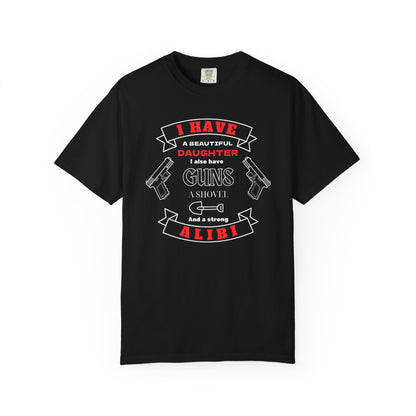 A black short-sleeve crewneck t-shirt with a graphic print on the front. The graphic features the text 'I have a beautiful daughter,i also have guns, a shovel and a strong alibi' in black and red lettering, accompanied by illustrations of two pistols and a shovel.