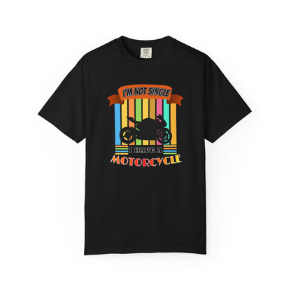 A black short-sleeve crewneck t-shirt with a colorful retro graphic on the chest. The graphic features a black motorcycle silhouette over vertical rainbow-colored stripes, with the text 'I'M NOT SINGLE' on an orange banner above and 'I HAVE A MOTORCYCLE' below.