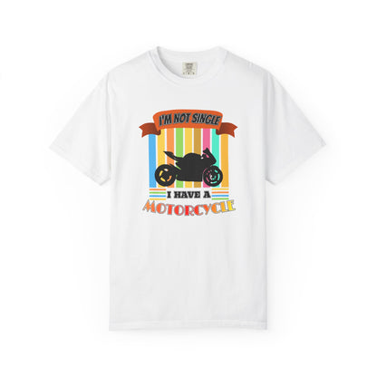 A white short-sleeve crewneck t-shirt featuring a retro-style graphic print with a black motorcycle silhouette and the text 'I'M NOT SINGLE I HAVE A MOTORCYCLE' on a background of vertical rainbow stripes.