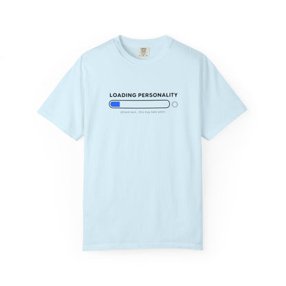 A light blue short-sleeve crewneck t-shirt with a graphic on the chest that reads 'LOADING PERSONALITY' above a progress bar with a blue filled segment and the text 'please wait.