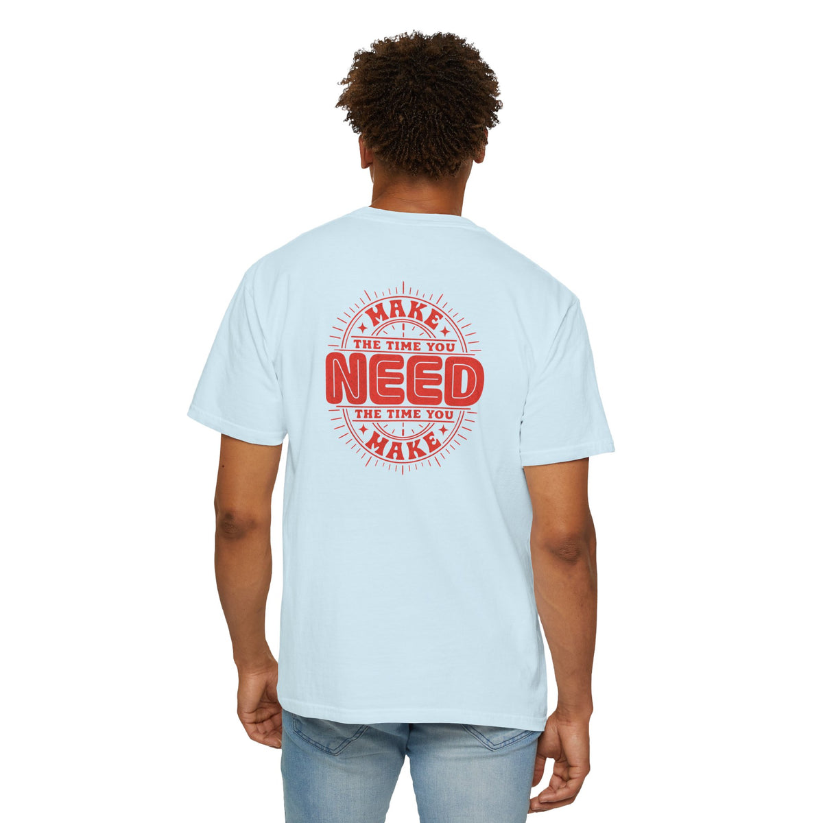 A man wearing a light blue short-sleeve crewneck t-shirt with a red circular graphic on the back that reads 'MAKE THE TIME YOU NEED THE TIME YOU MAKE'.