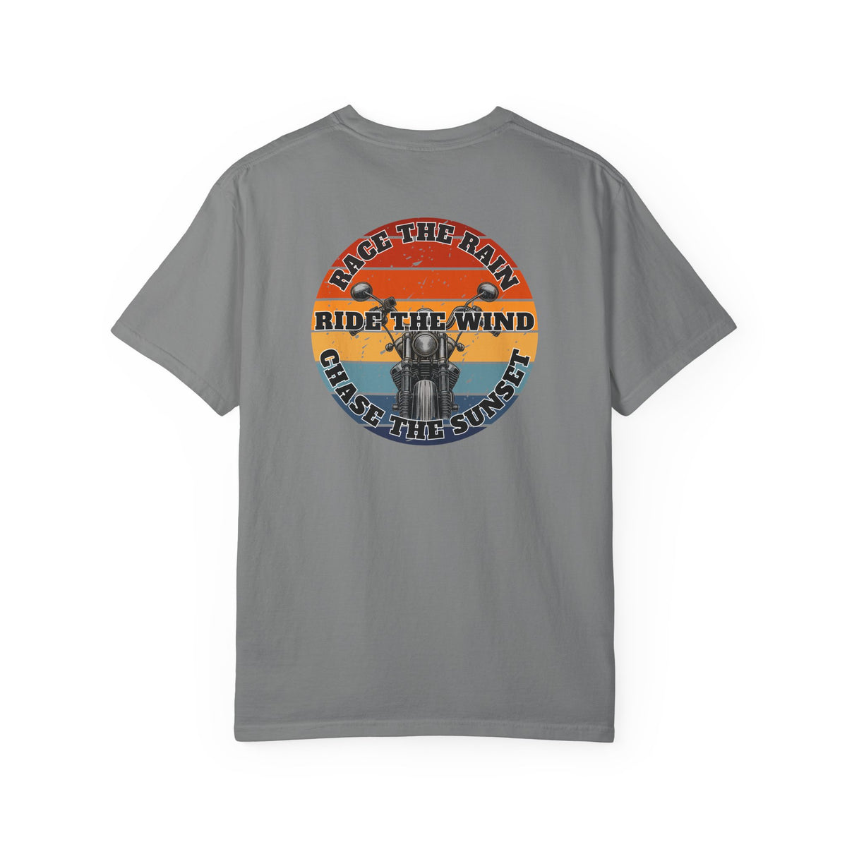 A gray short-sleeve crewneck t-shirt with a retro circular graphic on the chest. The graphic features a motorcycle silhouette and the text 'RACE THE RAIN', 'RIDE THE WIND', and 'CHASE THE SUNSET' in a distressed sunset color palette of orange, yellow, and blue.