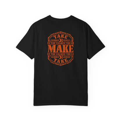 A black short-sleeve t-shirt with a distressed orange graphic on the back reading 'TAKE THE CHANCE YOU MAKE'.