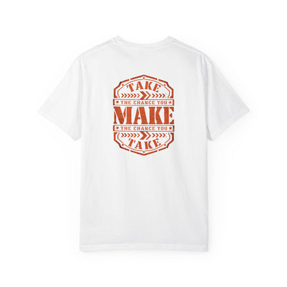 A white short-sleeve t-shirt with a distressed orange graphic on the back reading 'TAKE THE CHANCE YOU MAKE'.