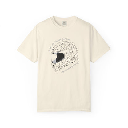 An ivory short-sleeve crewneck t-shirt featuring a black line art graphic of a geometric motorcycle helmet in the center, with the text 'When the helmet goes on, the world goes off' curved around it.