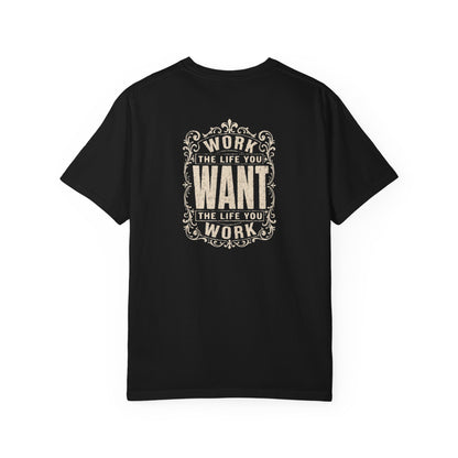 A black short-sleeve crewneck t-shirt with a dark white graphic print on the back. The graphic features the motivational quote 'WORK THE LIFE YOU WANT THE LIFE YOU WORK' in a decorative, vintage-style frame.